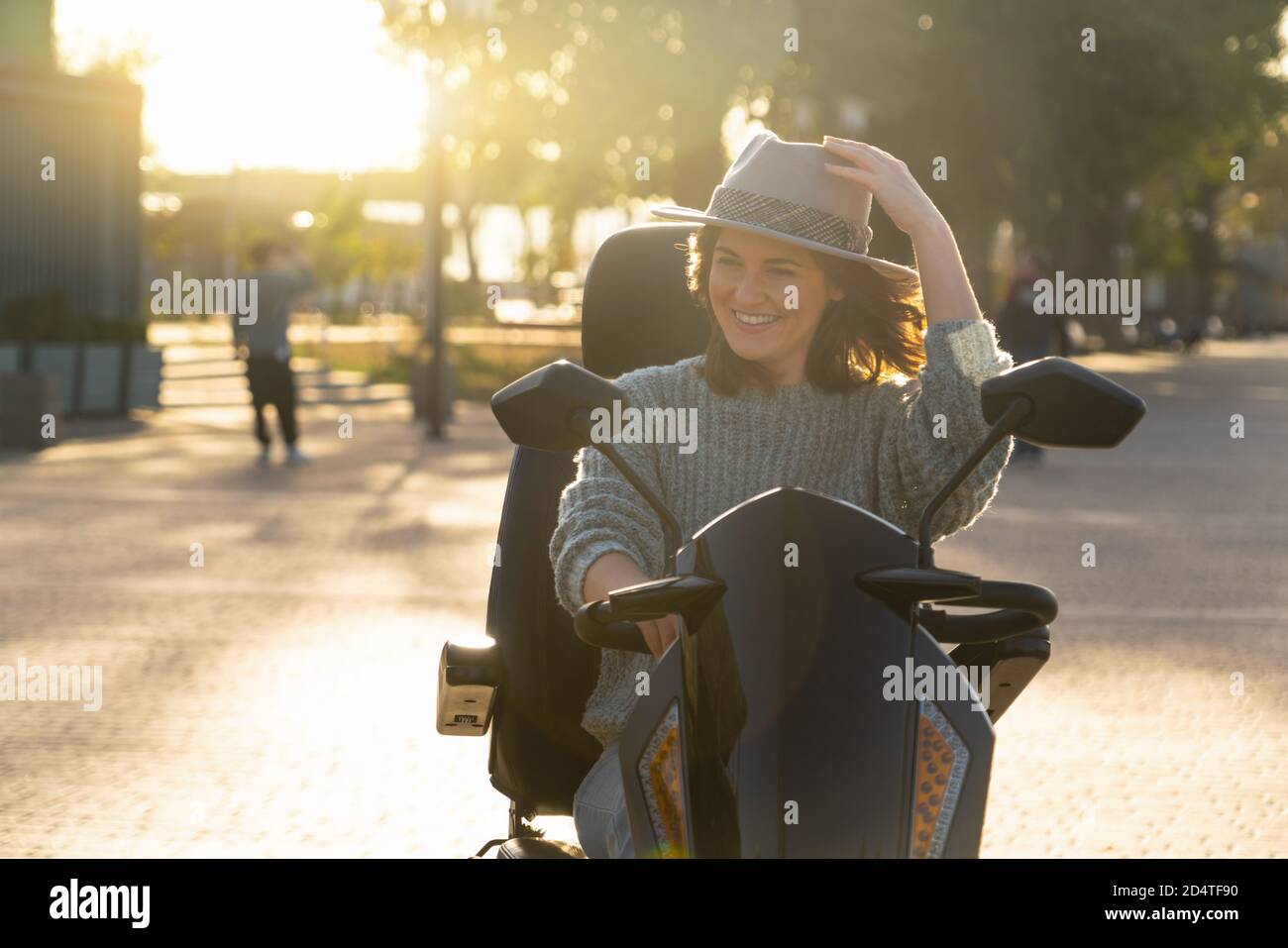 Femme touriste à bord d'un scooter électrique à quatre roues sur une rue de la ville. Banque D'Images