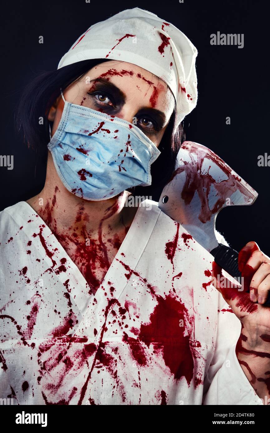 médecin de femme sanglante sombre avec une hache sur une noire arrière-plan Banque D'Images
