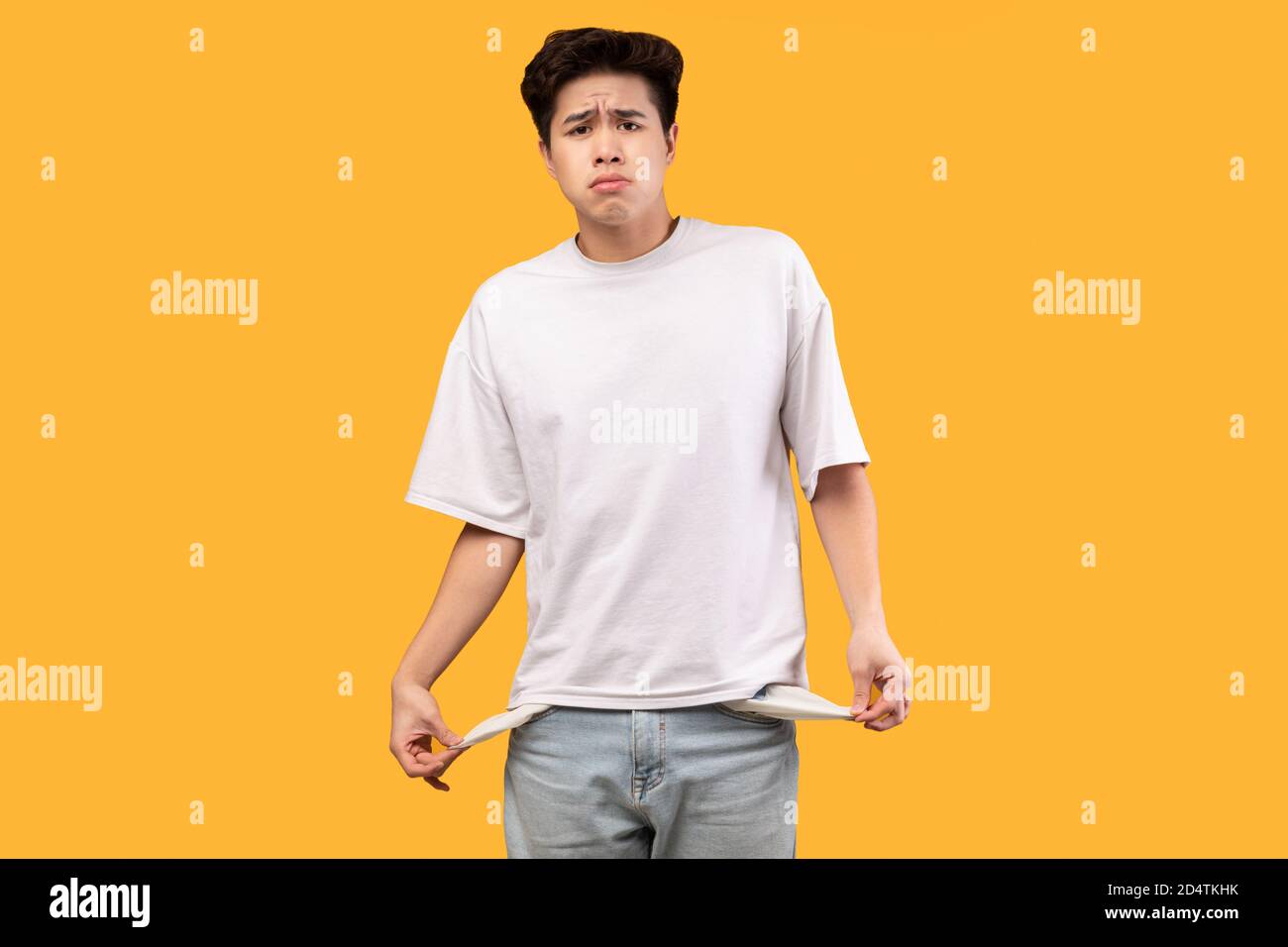 Portrait d'un homme asiatique montrant ses poches vides Banque D'Images