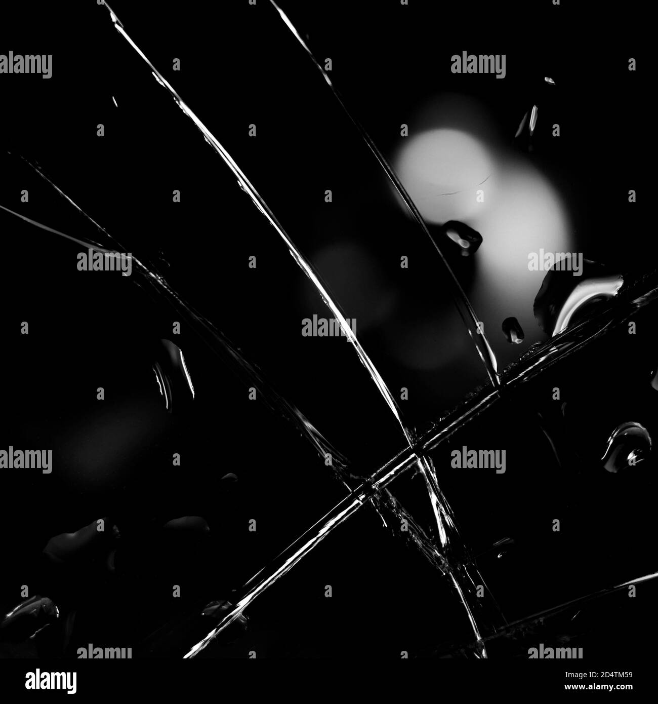 Fond en verre cassé en noir. Arrière-plan minimaliste noir avec fissures sur le verre et gouttes d'eau. Banque D'Images