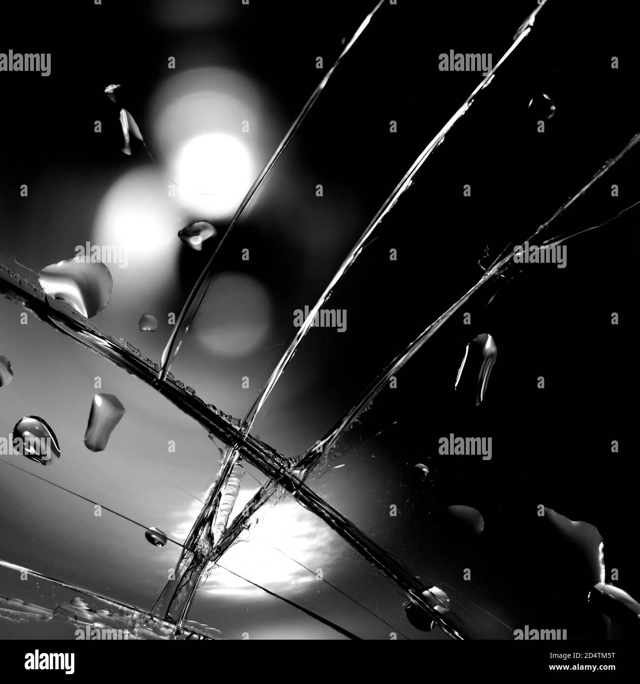 Fond en verre cassé en noir. Arrière-plan minimaliste noir avec fissures sur le verre et gouttes d'eau. Banque D'Images