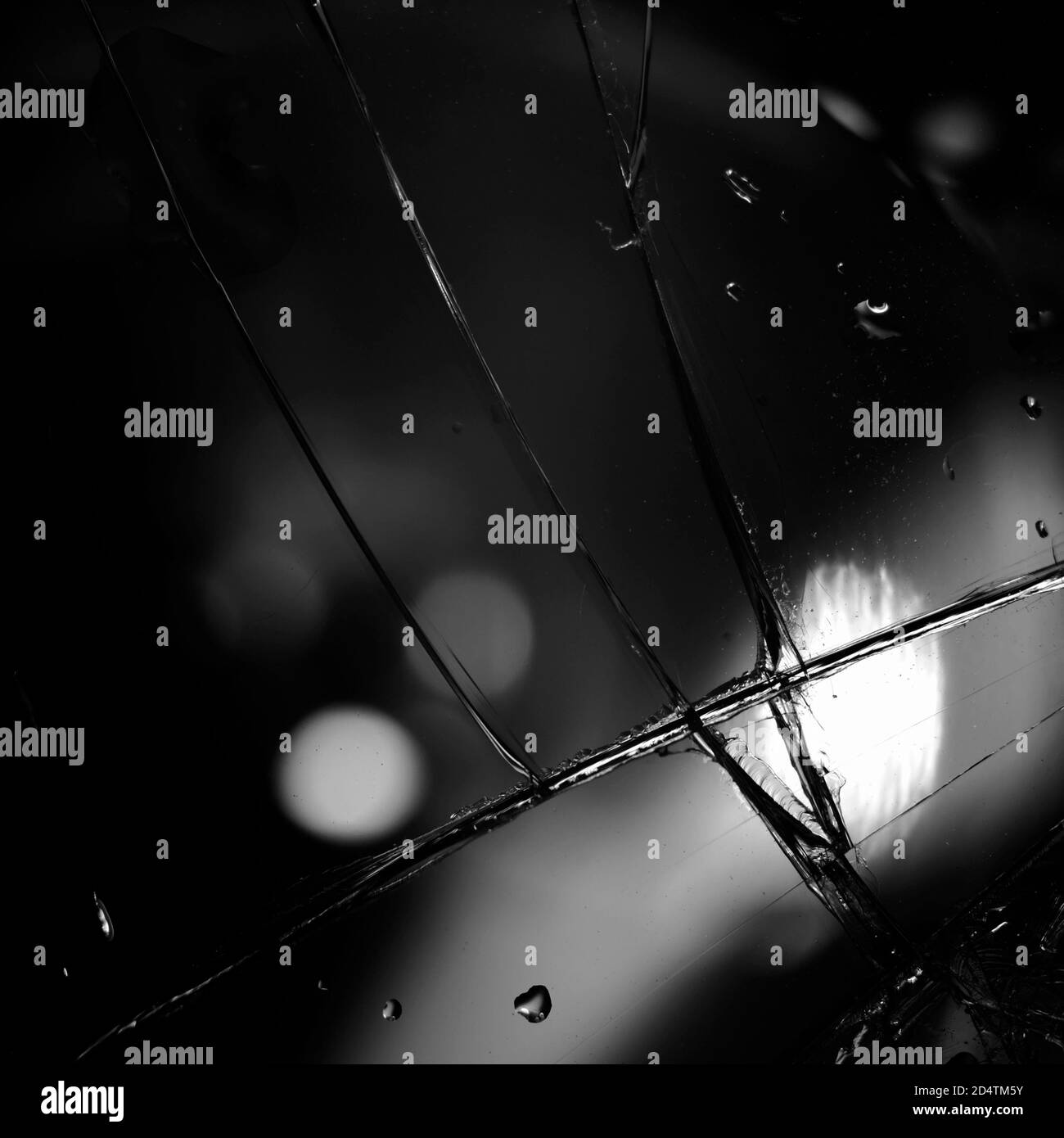 Fond en verre cassé en noir. Arrière-plan minimaliste noir avec fissures sur le verre et gouttes d'eau. Banque D'Images