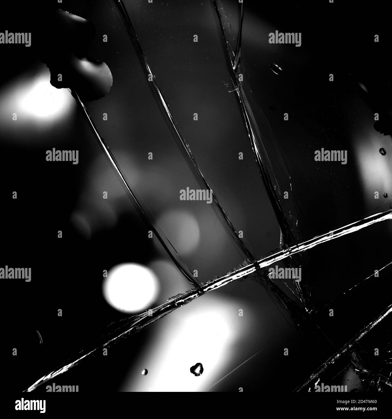 Fond en verre cassé en noir. Arrière-plan minimaliste noir avec fissures sur le verre et gouttes d'eau. Banque D'Images