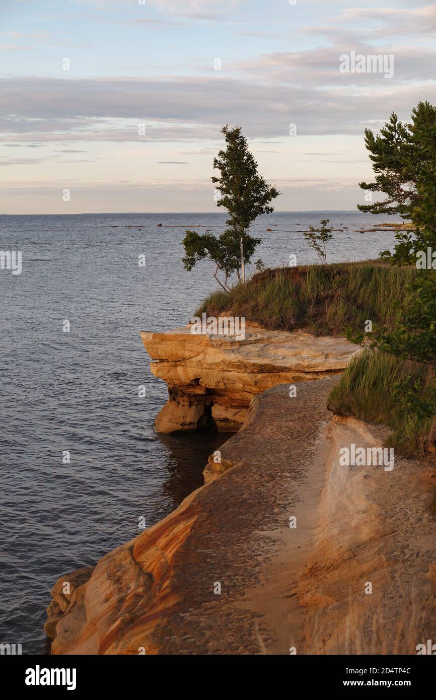 Paysage avec côte de mer solitaire et falaise de grès, heure du coucher du soleil. Estonie, Europe. Banque D'Images