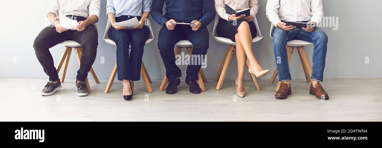 Groupe de candidats méconnus assis sur des chaises en attente d'une entrevue. Banque D'Images