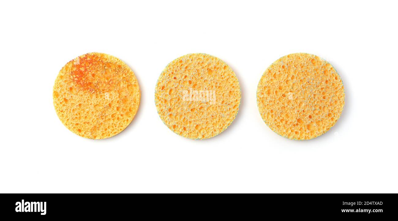 Éponges de lavage de visage jaunes isolées sur fond blanc, vue de dessus. Banque D'Images