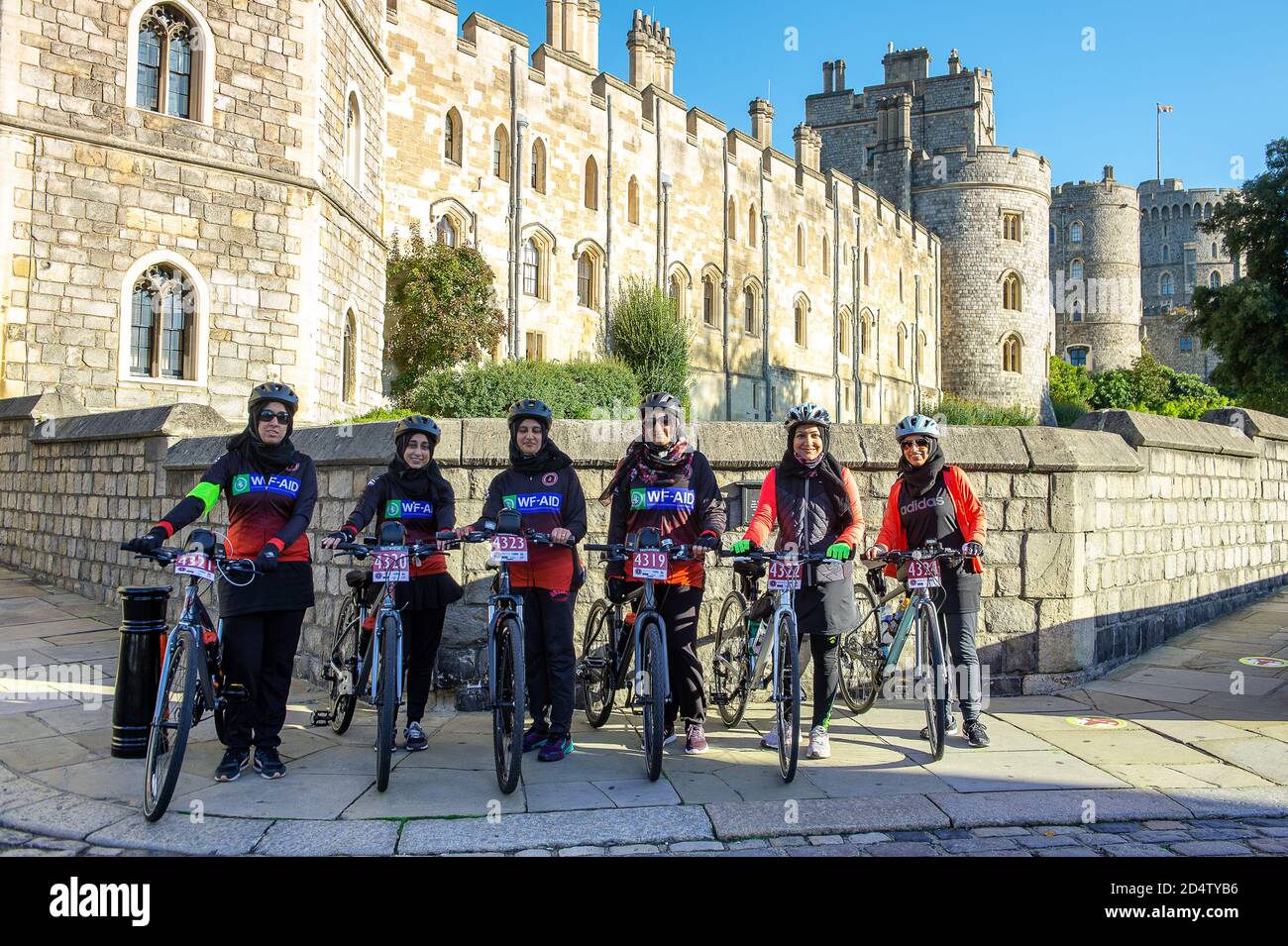 Windsor, Berkshire, Royaume-Uni. 11 octobre 2020. Ce matin, une fille pose pour une photo devant le château de Windsor alors qu'elle participe à une promenade en vélo parrainée par un organisme de bienfaisance de Stanmore à Windsor, en recueillant des fonds pour l'organisme international de bienfaisance WF-Aid. Vingt nouveaux cas de Covid-19 ont été signalés au cours des 24 dernières heures dans le quartier royal de Windsor et Maidenhead. Le gouvernement devrait annoncer un nouveau système de verrouillage à trois niveaux pour l'Angleterre après une deuxième pointe dans les cas positifs. Crédit : Maureen McLean/Alay Banque D'Images