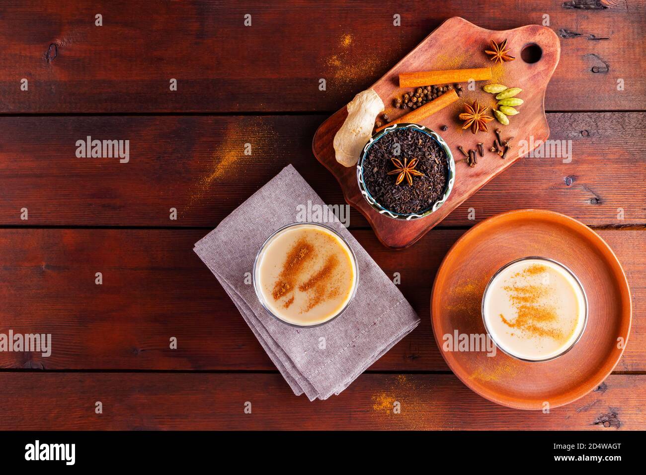 Deux verres de thé masala et divers ingrédients. Thé Chai au masala sur des planches en bois. Thé au lait et épices. Copier l'espace. Vue de dessus Banque D'Images