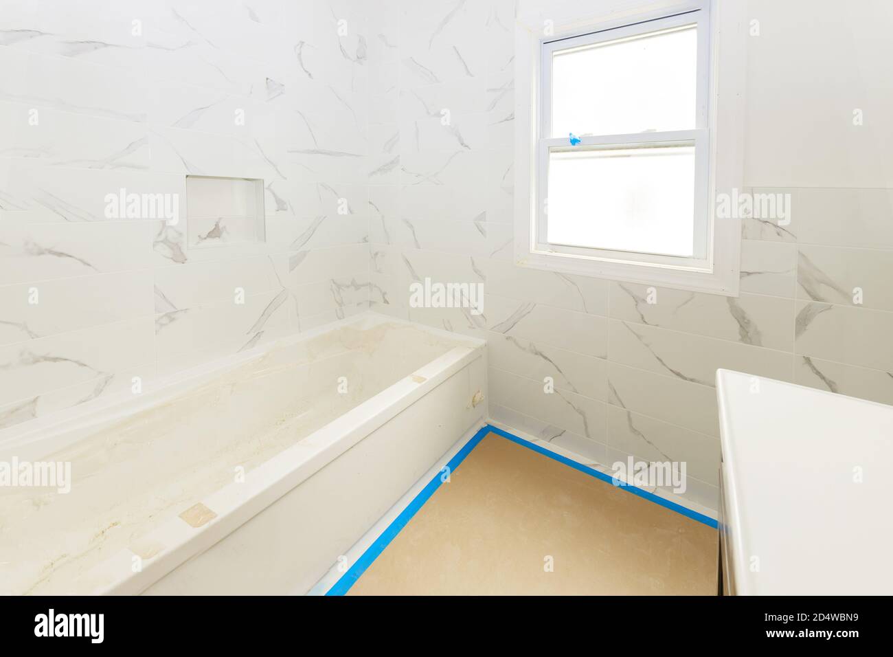 Salle de bains avec des murs carrelés et sol d'installation de douche et de lavabo, est dans l'appartement qui est en construction de la maison Banque D'Images