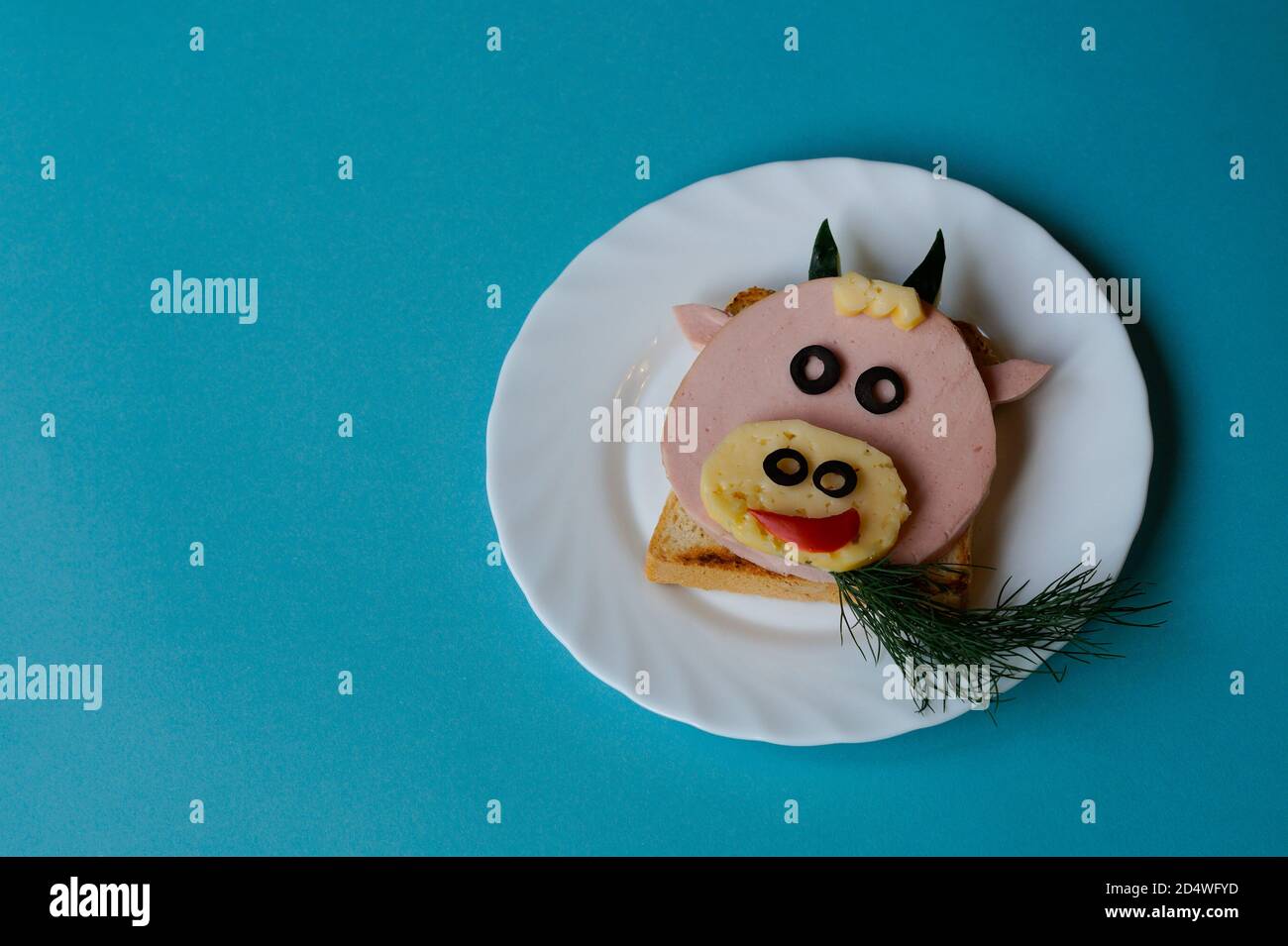 Idée drôle de petit déjeuner pour les enfants. Sandwich en forme de vache à bœuf à base de pain, saucisse, fromage. Vue de dessus de la nourriture de Noël du nouvel an avec espace pour les copies Banque D'Images