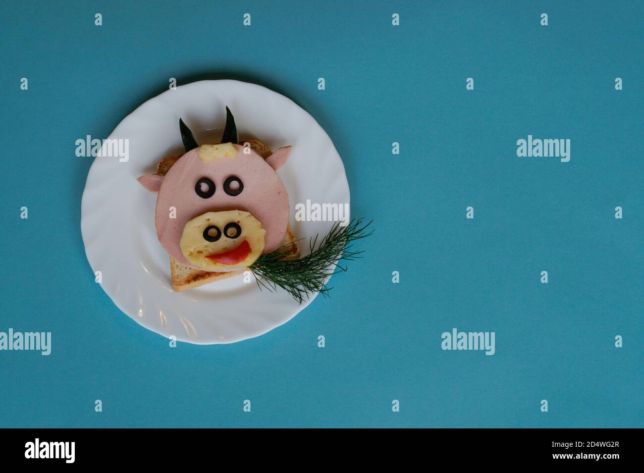 Idée drôle de petit déjeuner pour les enfants. Sandwich en forme de vache à bœuf à base de pain, saucisse, fromage. Vue de dessus de la nourriture de Noël du nouvel an avec espace pour les copies Banque D'Images