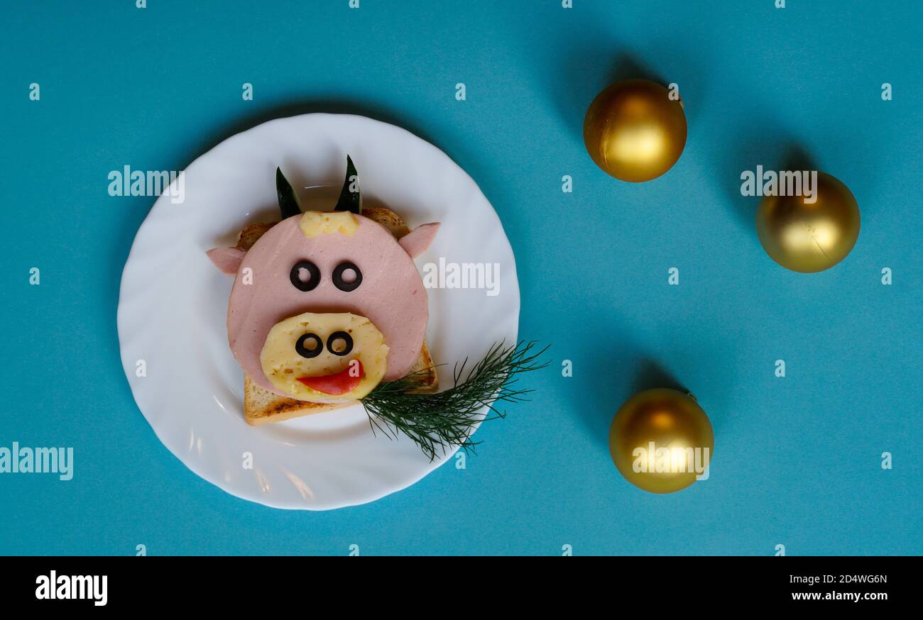 Idée drôle de petit déjeuner pour les enfants. Sandwich en forme de vache à bœuf à base de pain, saucisse, fromage. Vue de dessus de la nourriture de Noël du nouvel an avec espace pour les copies Banque D'Images