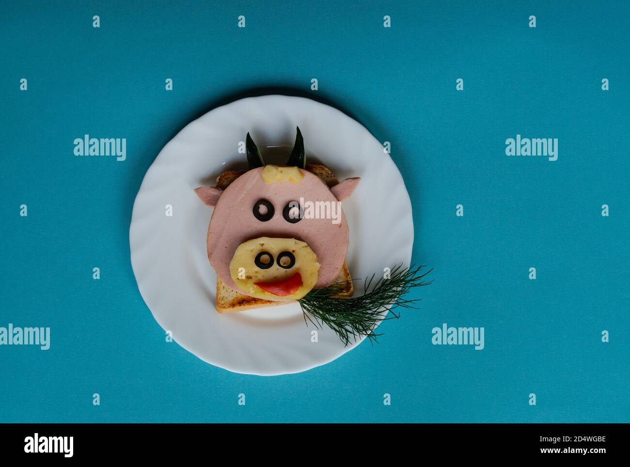 Sandwich drôle avec symbole comestible de 2021 vache à taureau fait de pain grillé, saucisse et fromage, idée de petit déjeuner pour les enfants. vacances, célébration, art de la nourriture Banque D'Images