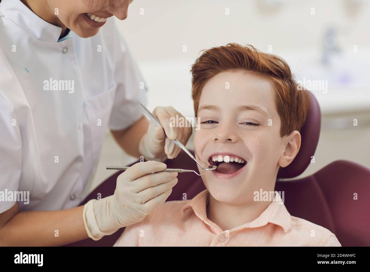 Enregistrement d'un enfant garçon souriant dans le cabinet du dentiste. Prévention des caries et traitement dentaire. Banque D'Images
