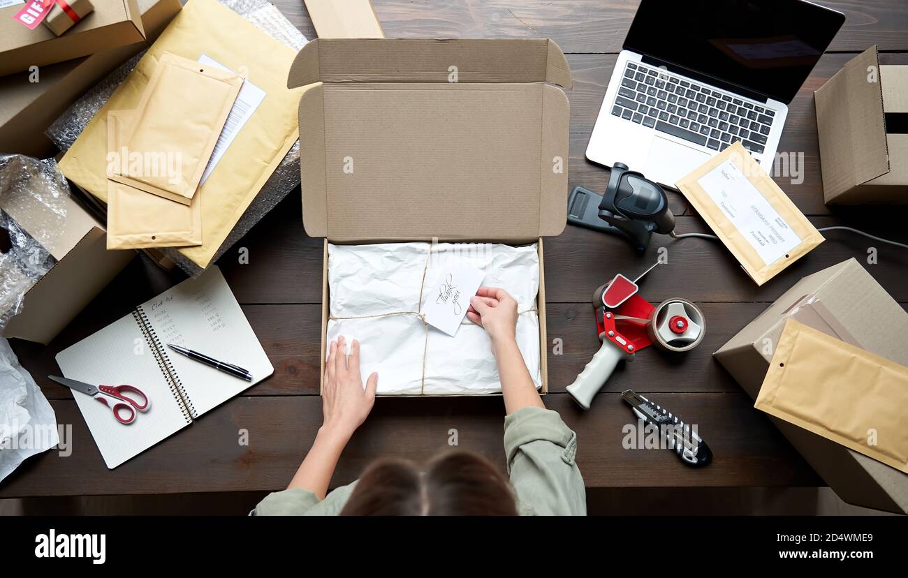 Vue de dessus de la femelle magasin en ligne propriétaire d'affaires emballage ecommerce boîte d'expédition. Banque D'Images