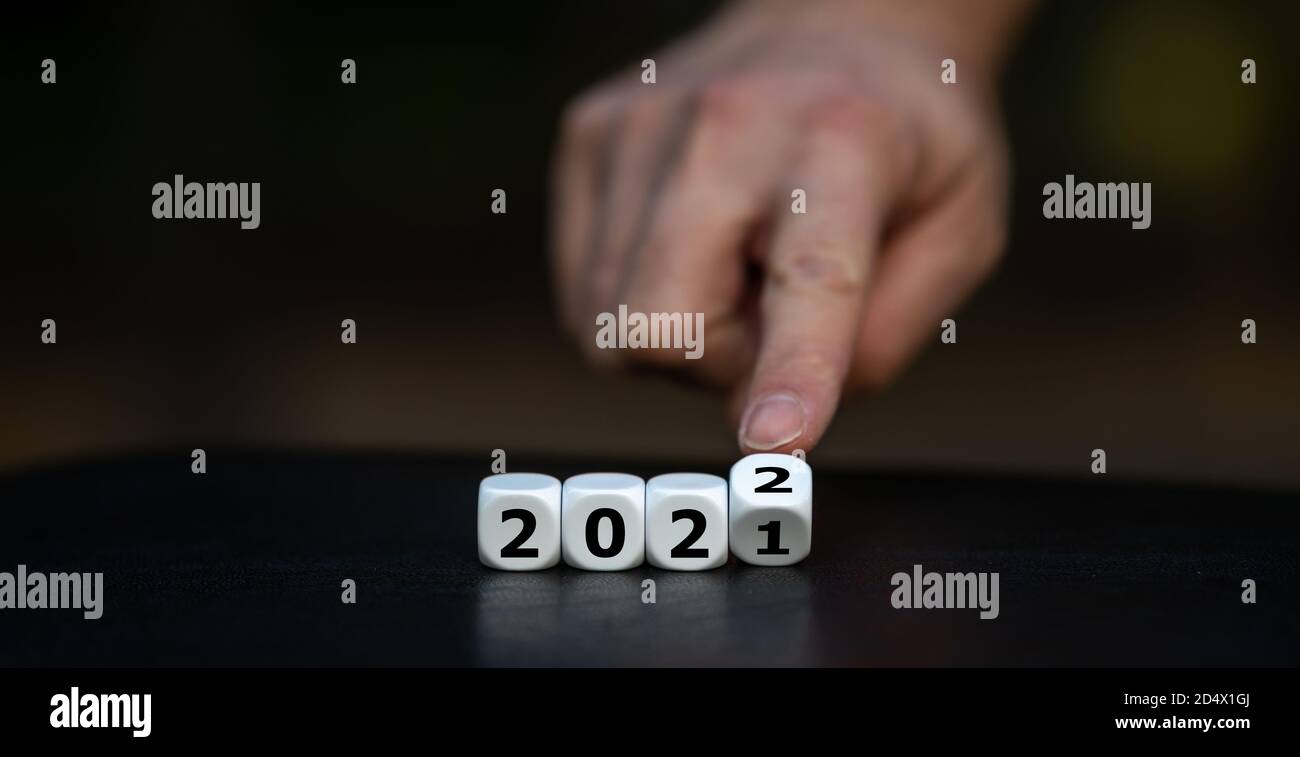 La main tourne les dés et change l'année 2021 à 2022. Banque D'Images