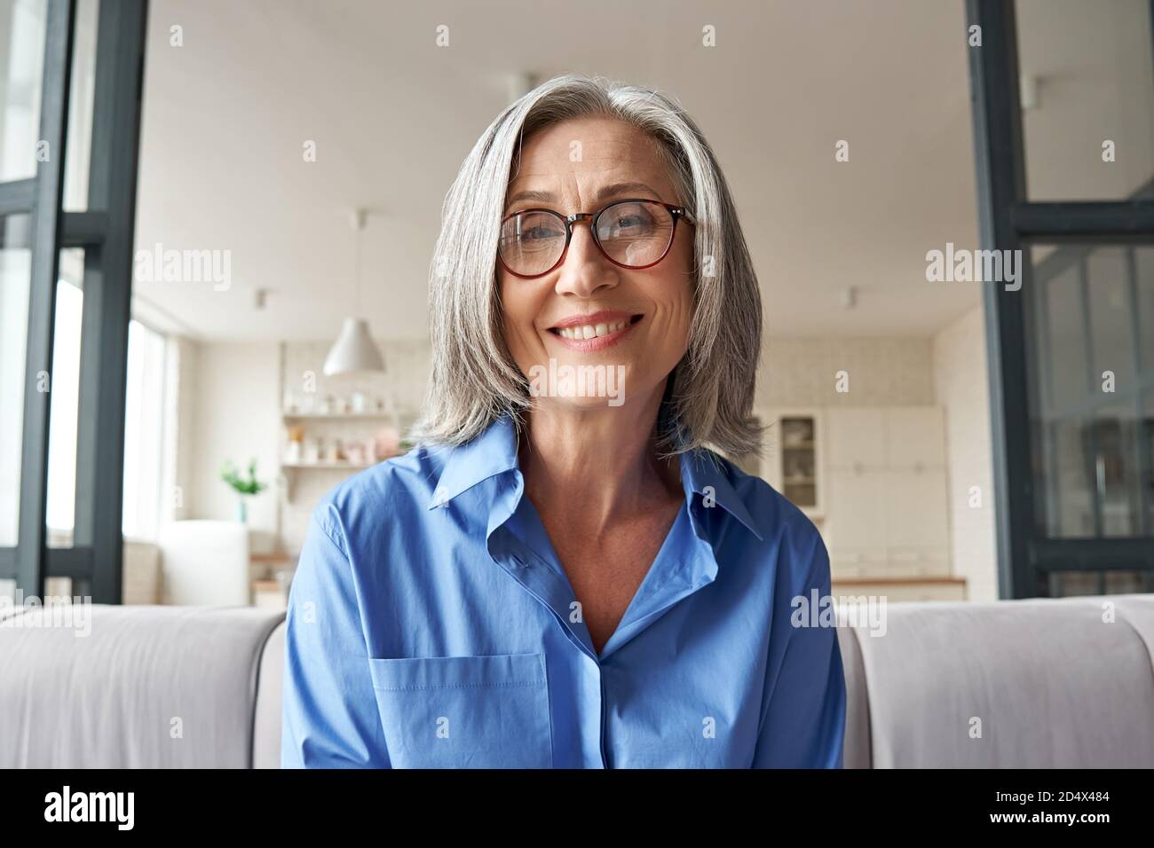 Femme mûre souriante regardant la caméra, webcam tête de vue. Banque D'Images