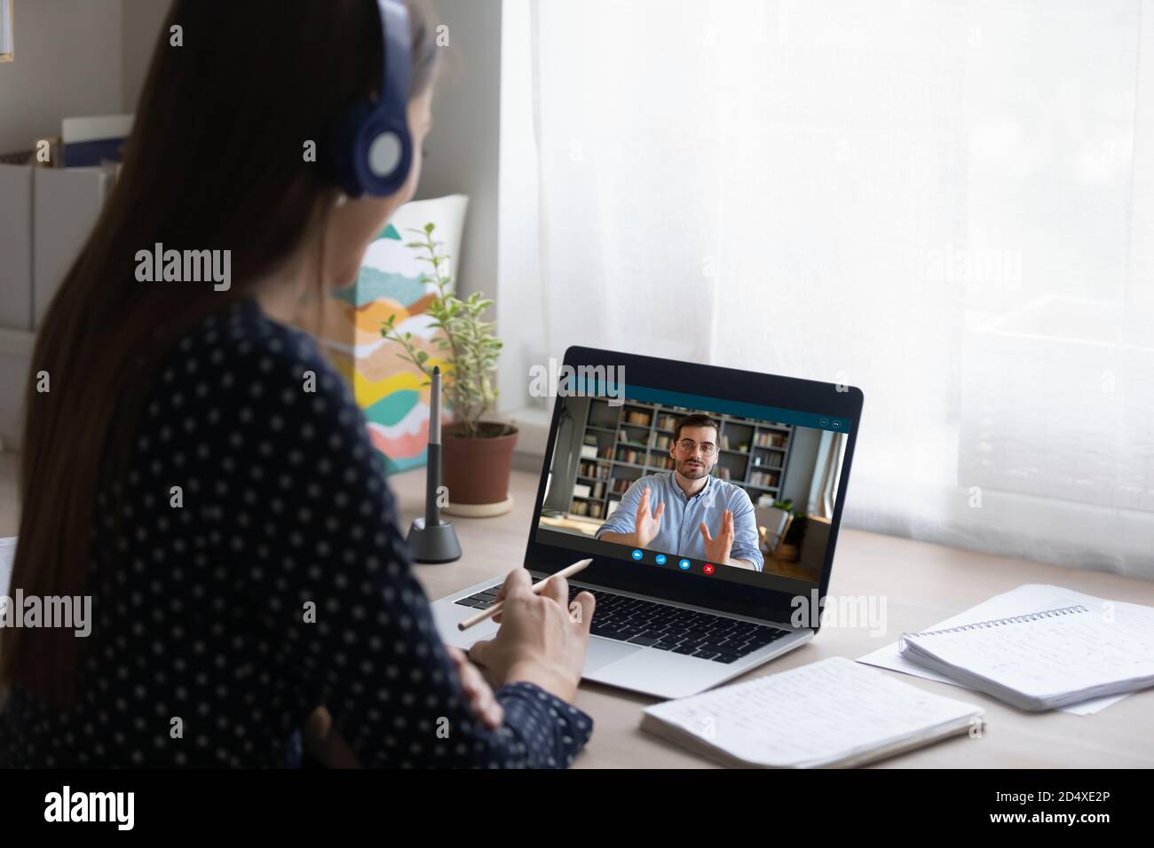Jeune étudiante consultant en ligne avec professeur. Banque D'Images