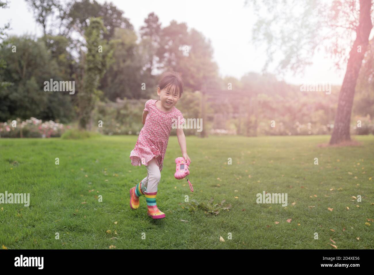 jeune fille qui court dans le jardin d'été le matin Banque D'Images