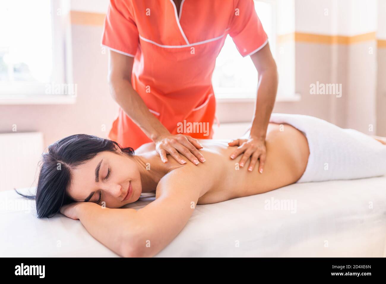 La jeune femme a un massage médical de récupération. Gros plan d'une femme se détendant pendant un massage du dos et du cou Banque D'Images