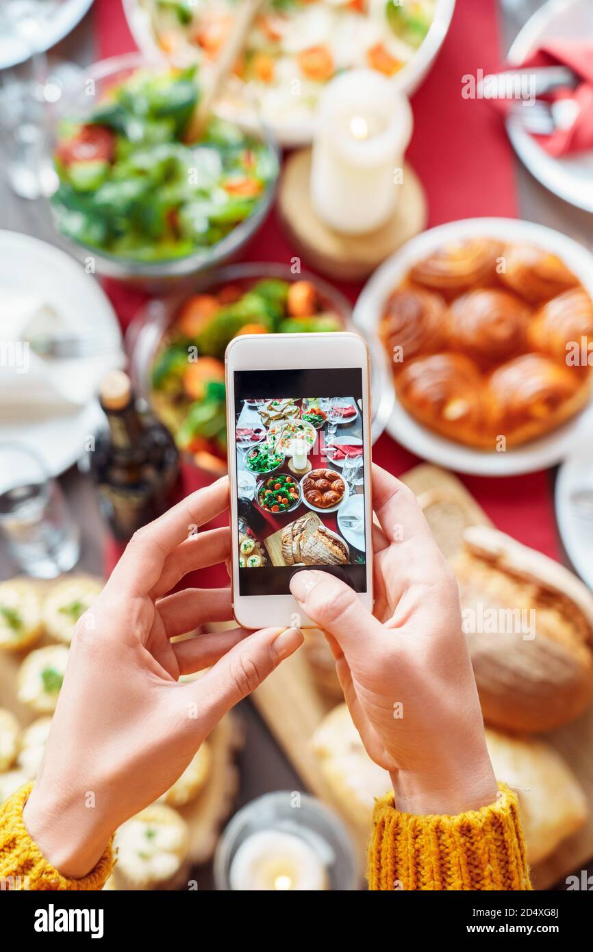 Femme prenant des photos avec table de dîner sur smartphone Banque D'Images