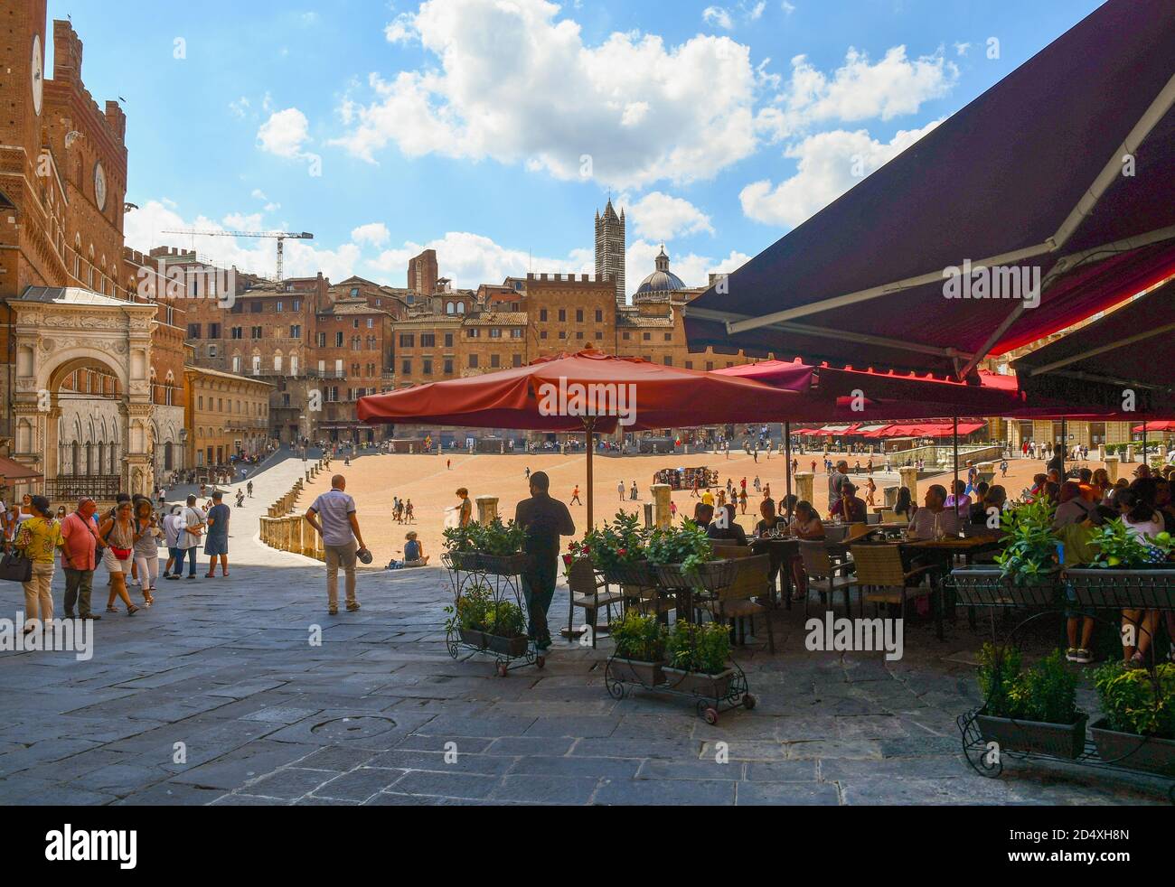 Café en plein air bondé de touristes sur la Piazza del Campo, place principale de la vieille ville de Sienne, patrimoine de l'UNESCO W., en été, Toscane, Italie Banque D'Images