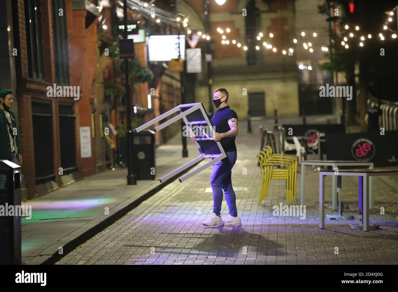 Le personnel se défait des tables pour la soirée à Manchester, en prévision d'une éventuelle annonce du gouvernement lundi. Dans les villes du nord de l'Angleterre et dans d'autres régions qui souffrent d'une augmentation des cas de Covid-19, les pubs et les restaurants peuvent être temporairement fermés pour lutter contre la propagation du virus. Banque D'Images