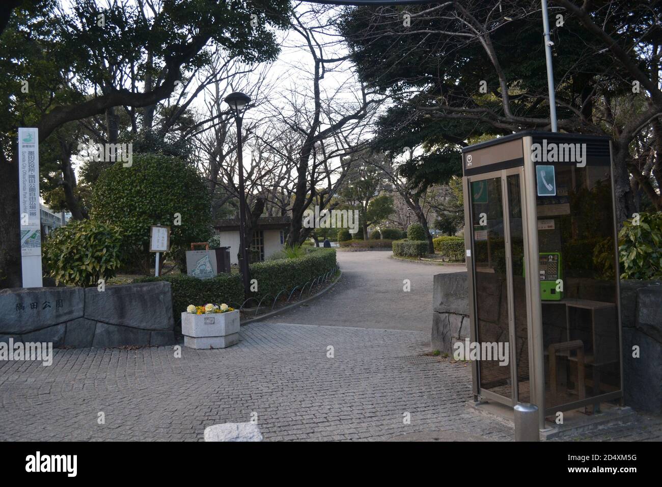 Tokyo, Japon-3/01/16: Une cabine téléphonique japonaise classique unique avec un téléphone vert; situé dans la section du parc Sumida avec des arbres verts et des buissons. Banque D'Images