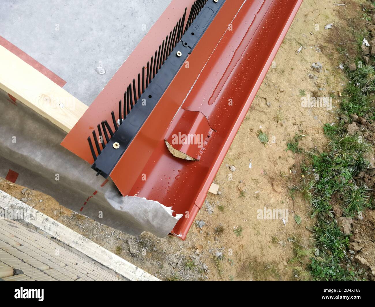 Gouttière avec tuyau de descente pour la collecte de l'eau de pluie sur la maison en construction sur le chantier Banque D'Images