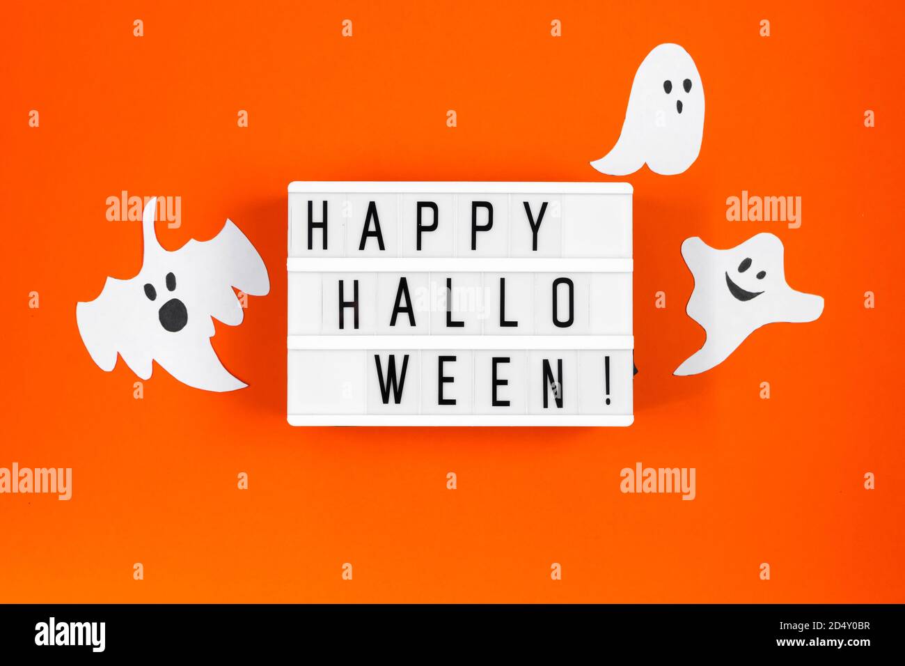Concept Halloween. Décorations de fête - fantômes en papier et toile d'araignée sur fond orange. Banque D'Images