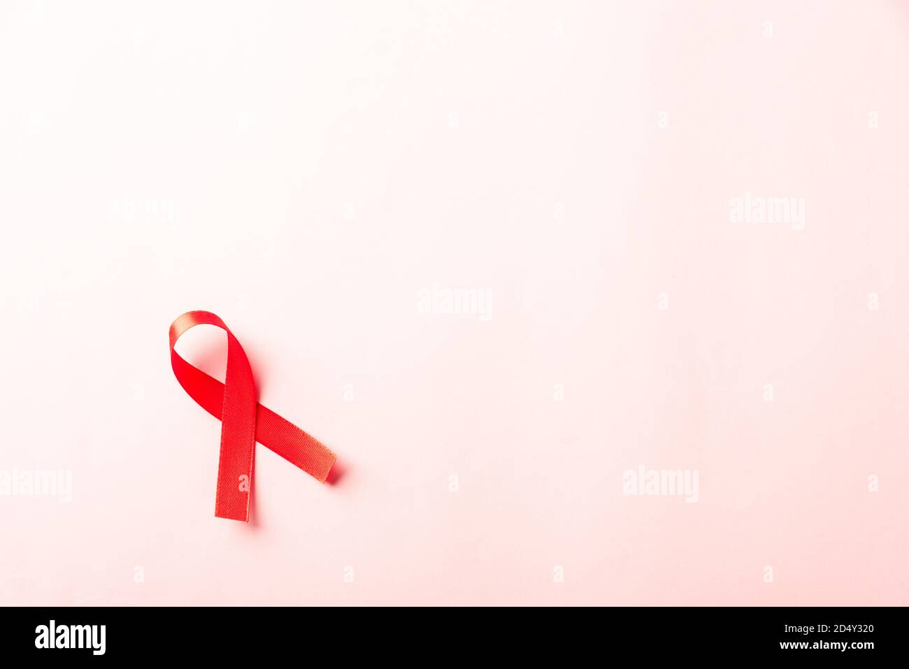 Ruban rouge symbole VIH, sensibilisation au cancer du sida avec ombres, tir  en studio isolé sur fond rose, concept de médecine de santé, Journée  mondiale du sida Photo Stock - Alamy