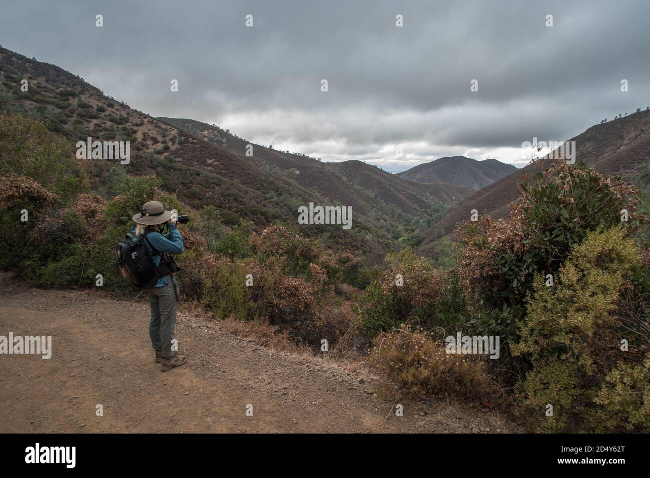 Un randonneur s'arrête pour prendre une photo d'une vallée au milieu des collines du parc national du Mont Diablo en Californie, aux États-Unis. Banque D'Images