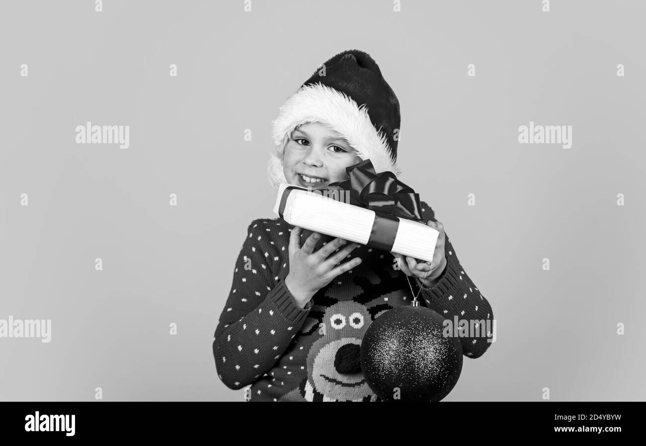 Nouvelle année de préparation. Les achats de Noël le temps. magasin de jouets et cadeaux pour enfants. smiling child in santa hat. Laissez votre Noël être lumineux. le bonheur de la petite enfance. Peu de maintien automatique et décoration cadeaux balle. Banque D'Images