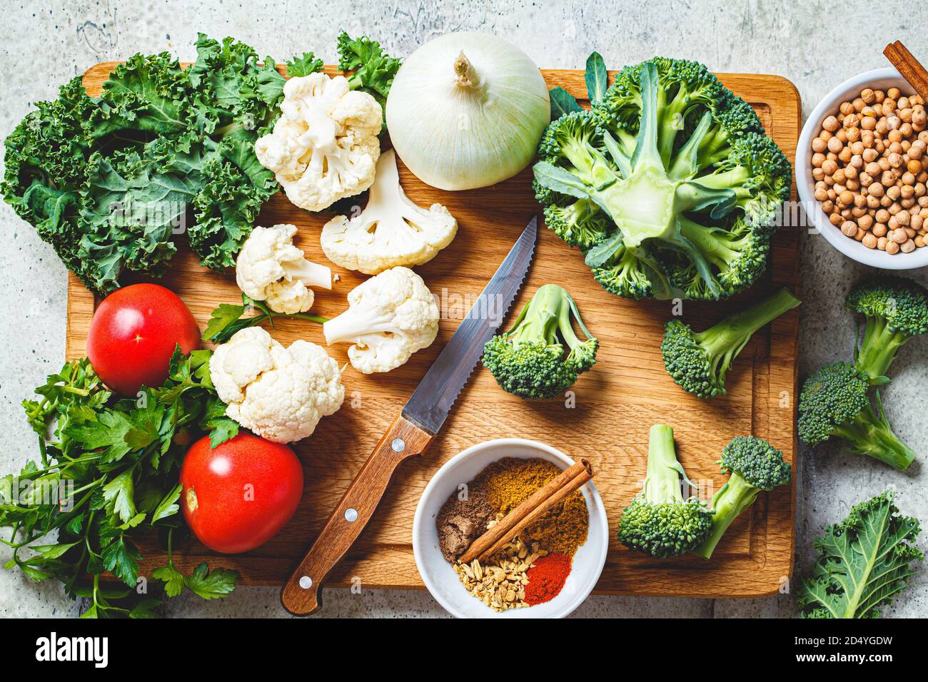 Fond de cuisson avec des légumes frais, des épices et des haricots. Ingrédients crus pour la cuisson du curry végétarien avec des légumes et des pois chiches sur un boa bois Banque D'Images