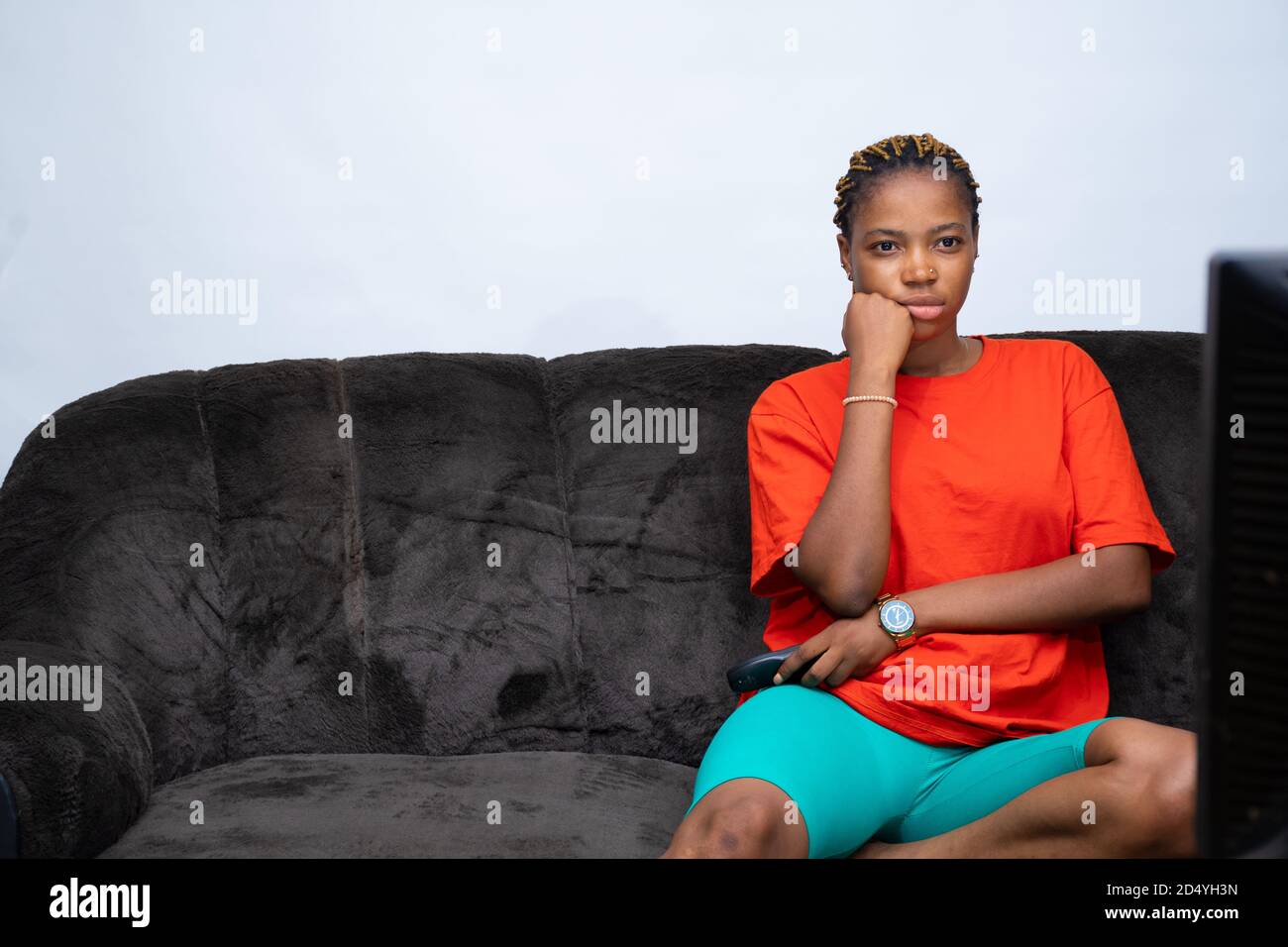 La jeune femme africaine s'est ennuyé avec ce qu'elle regarde à la télévision Banque D'Images