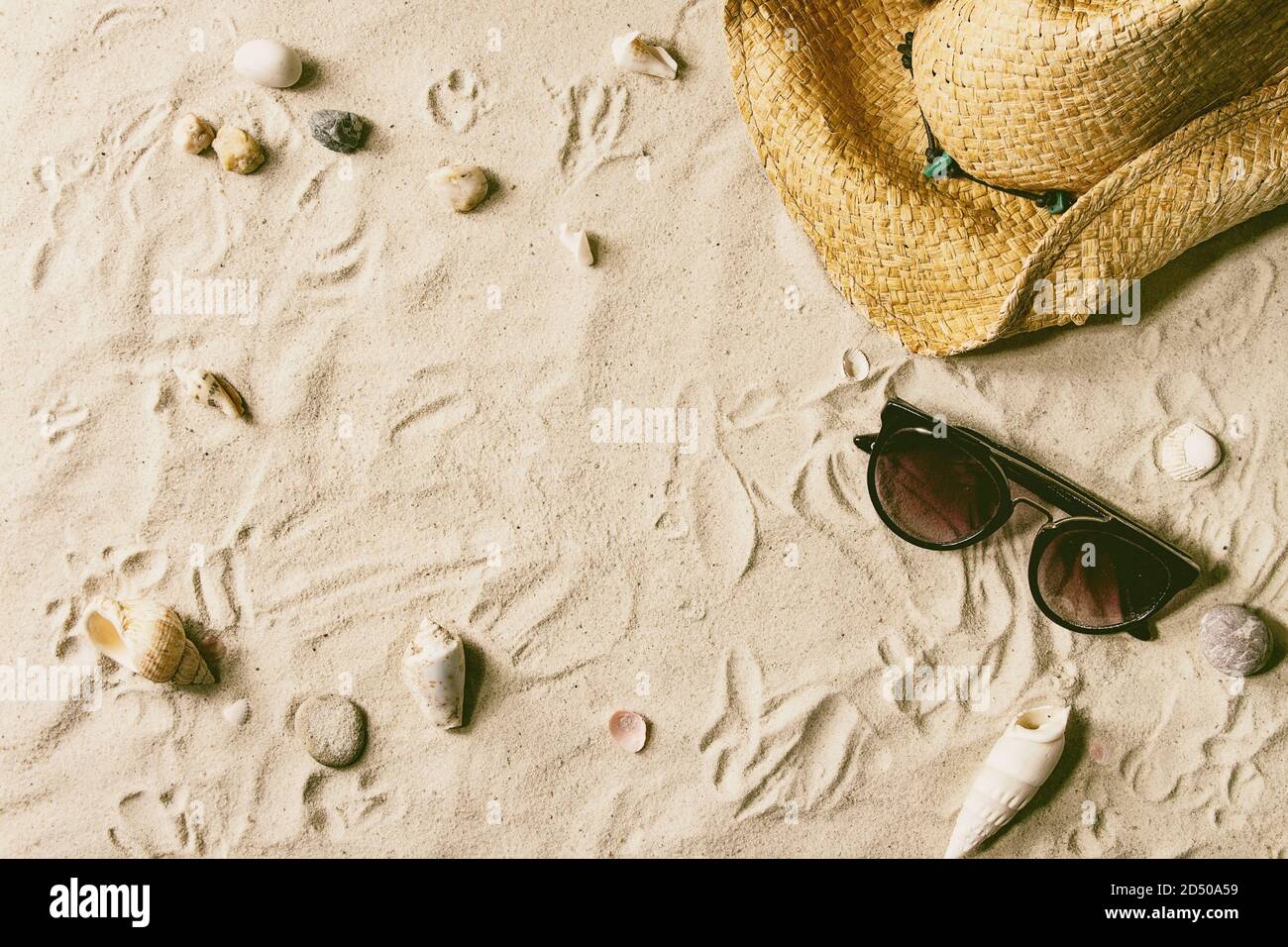 Thème d'été. Coquillages, pierres de mer, lunettes de soleil et chapeau de paille sur sable blanc comme arrière-plan. Pose à plat Banque D'Images