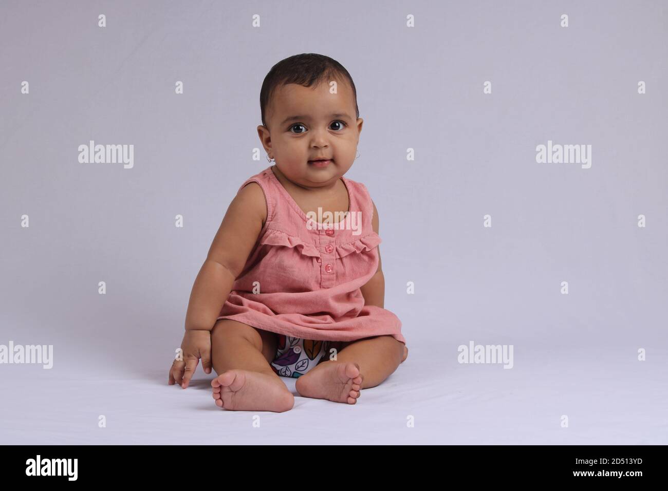 Mignon Indien Gai Bebe Assis Et Souriant Sur Blanc Photo Stock Alamy