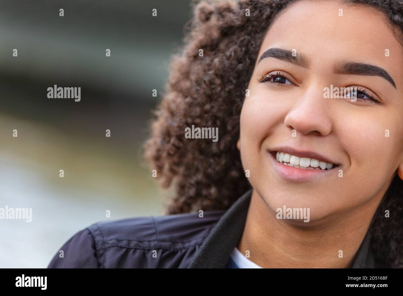 Bonne fille ou jeune femme afro-américaine souriante et mixte avec des dents parfaites Banque D'Images