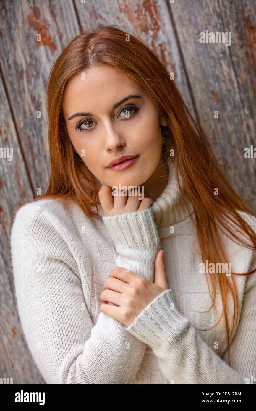 Portrait extérieur de belle pensée triste ou déprimé fille ou jeune femme aux cheveux rouges portant un pull blanc Banque D'Images