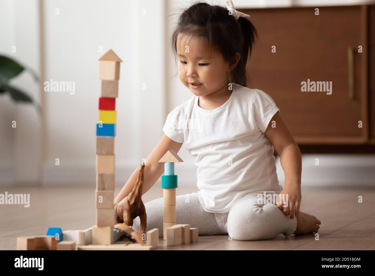 Gros plan jolie petite fille asiatique jouant des cubes en bois Banque D'Images