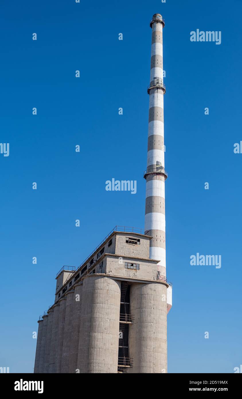 Ancienne usine industrielle abandonnée. Silos en béton et cheminée dans l'usine d'engrais. Drapetsona Pirée Grèce, ciel bleu, jour ensoleillé. Banque D'Images