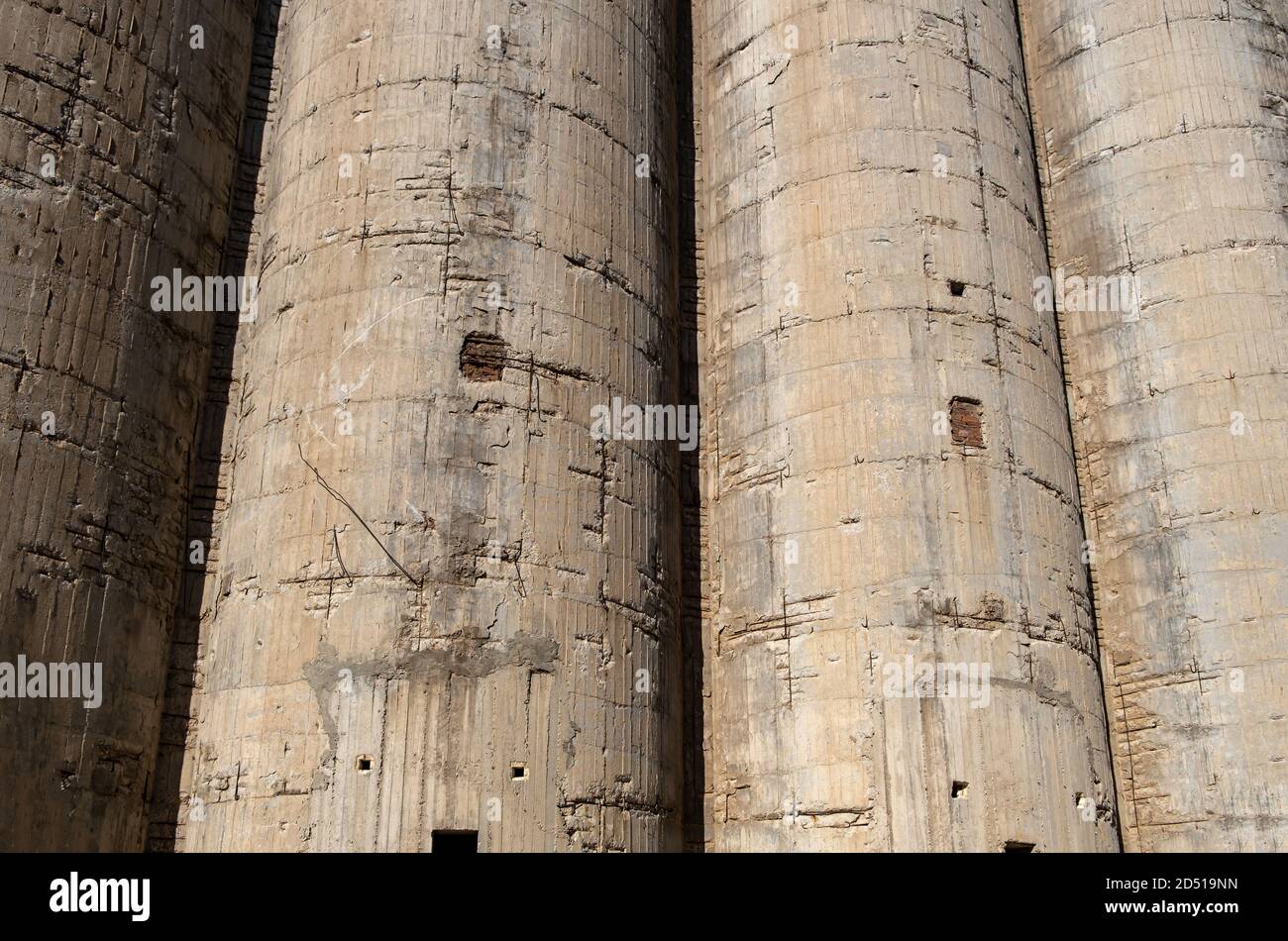 Les silos en béton détaillent la texture d'arrière-plan. Ancienne usine industrielle abandonnée, béton ruiné et acier rouillé, ragoût de clôture. Banque D'Images