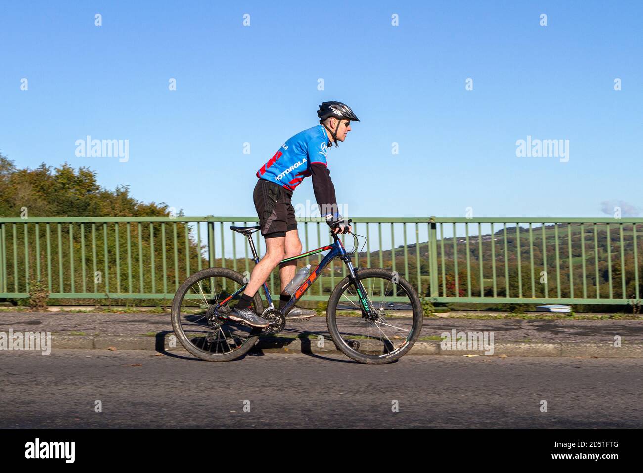 Cycliste de sport en fibre de carbone vélo de route sur la route de campagne traversant le pont d'autoroute dans la campagne du Lancashire, Royaume-Uni Banque D'Images