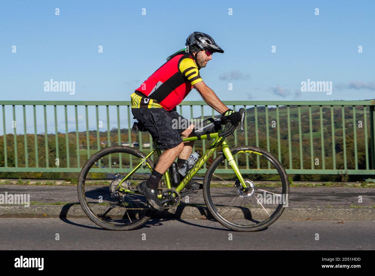 Cycliste mâle à bord d'un vélo de route Whyte en fibre de carbone sur la route de campagne traversant le pont d'autoroute dans la campagne du Lancashire, Royaume-Uni Banque D'Images