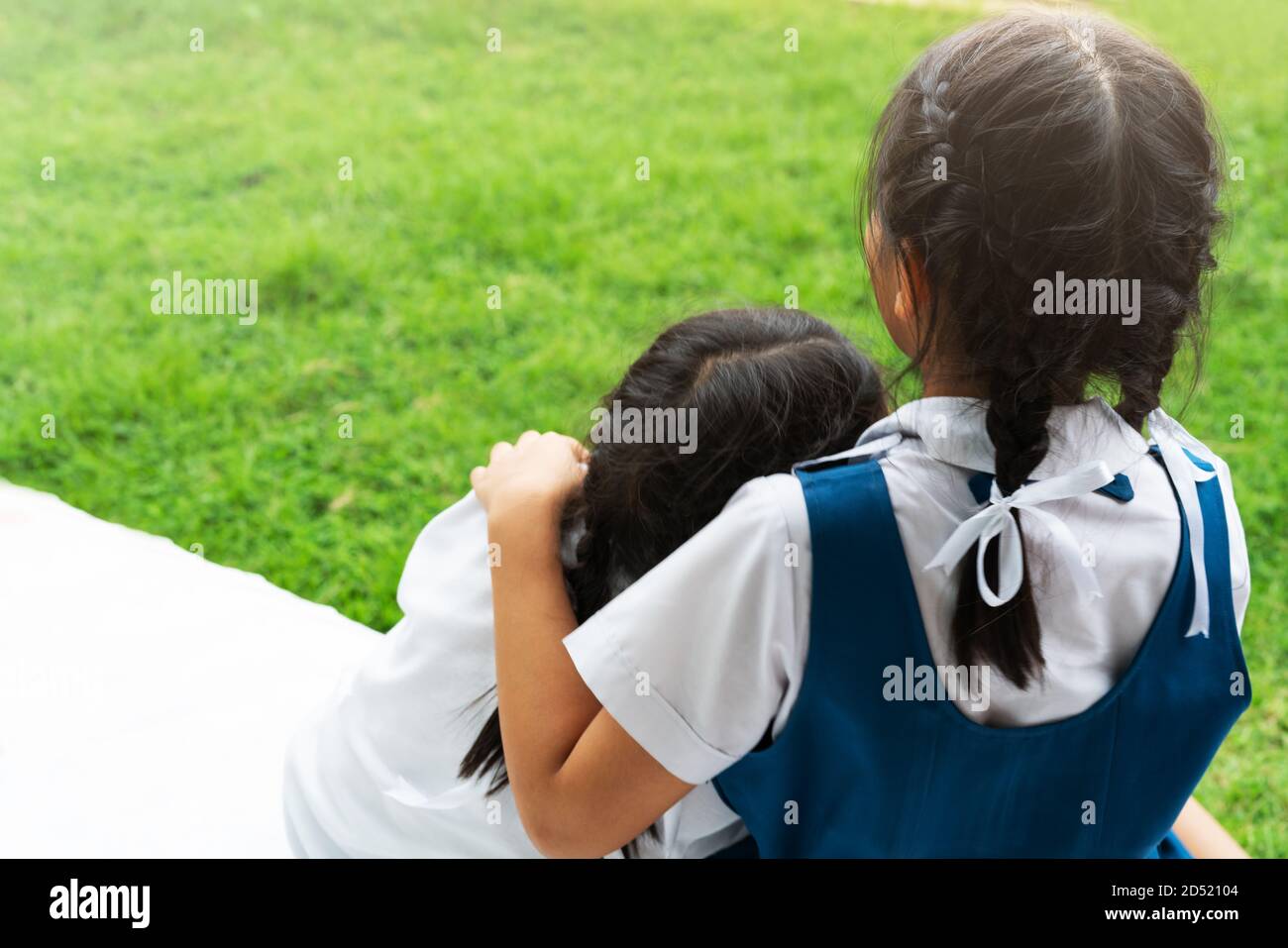 Deux petites filles asiatiques sisters hugging heureux post dans l'uniforme scolaire, concept retour à l'école Banque D'Images