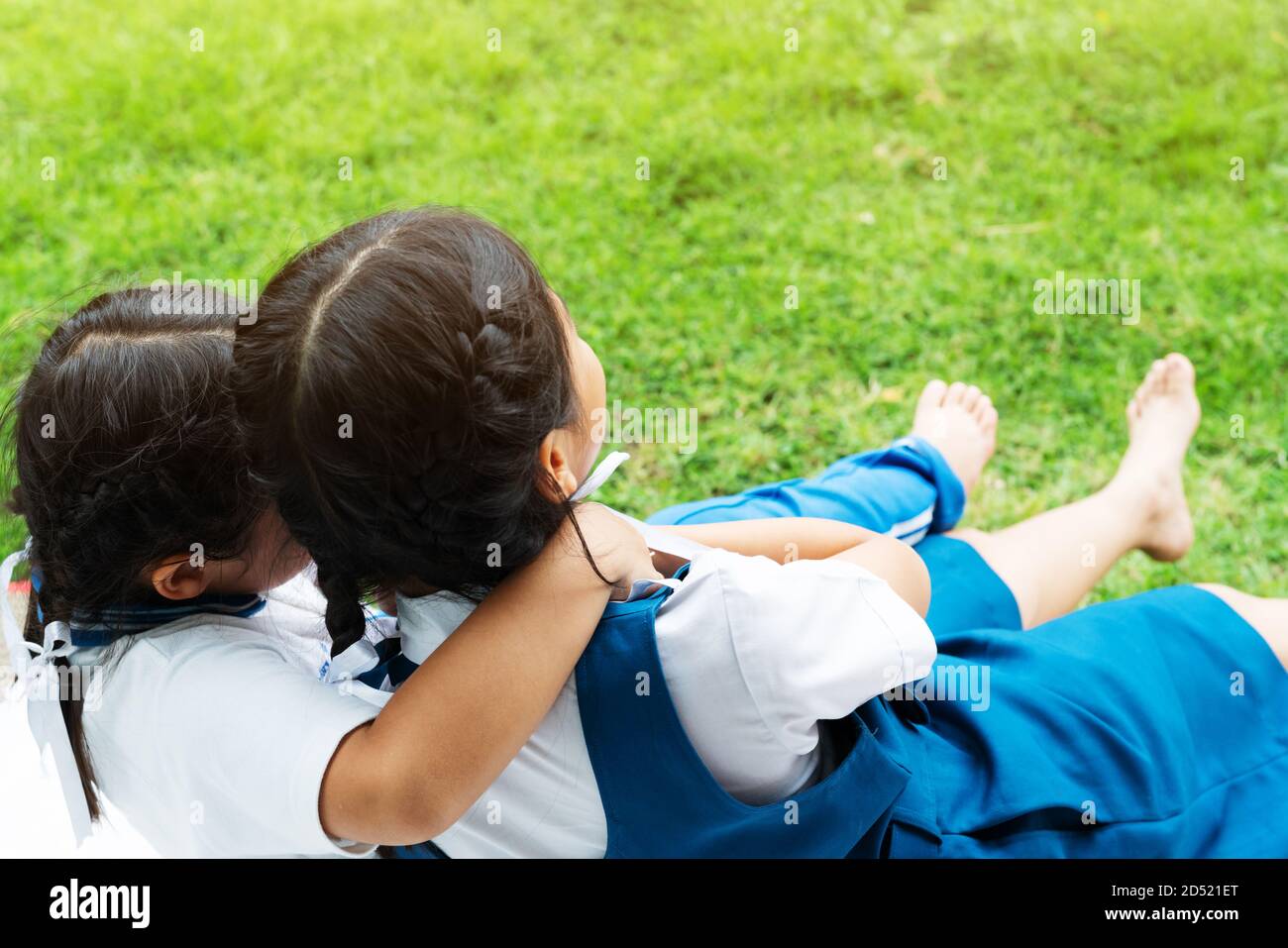 Deux petites filles asiatiques sisters hugging heureux post dans l'uniforme scolaire, concept retour à l'école Banque D'Images