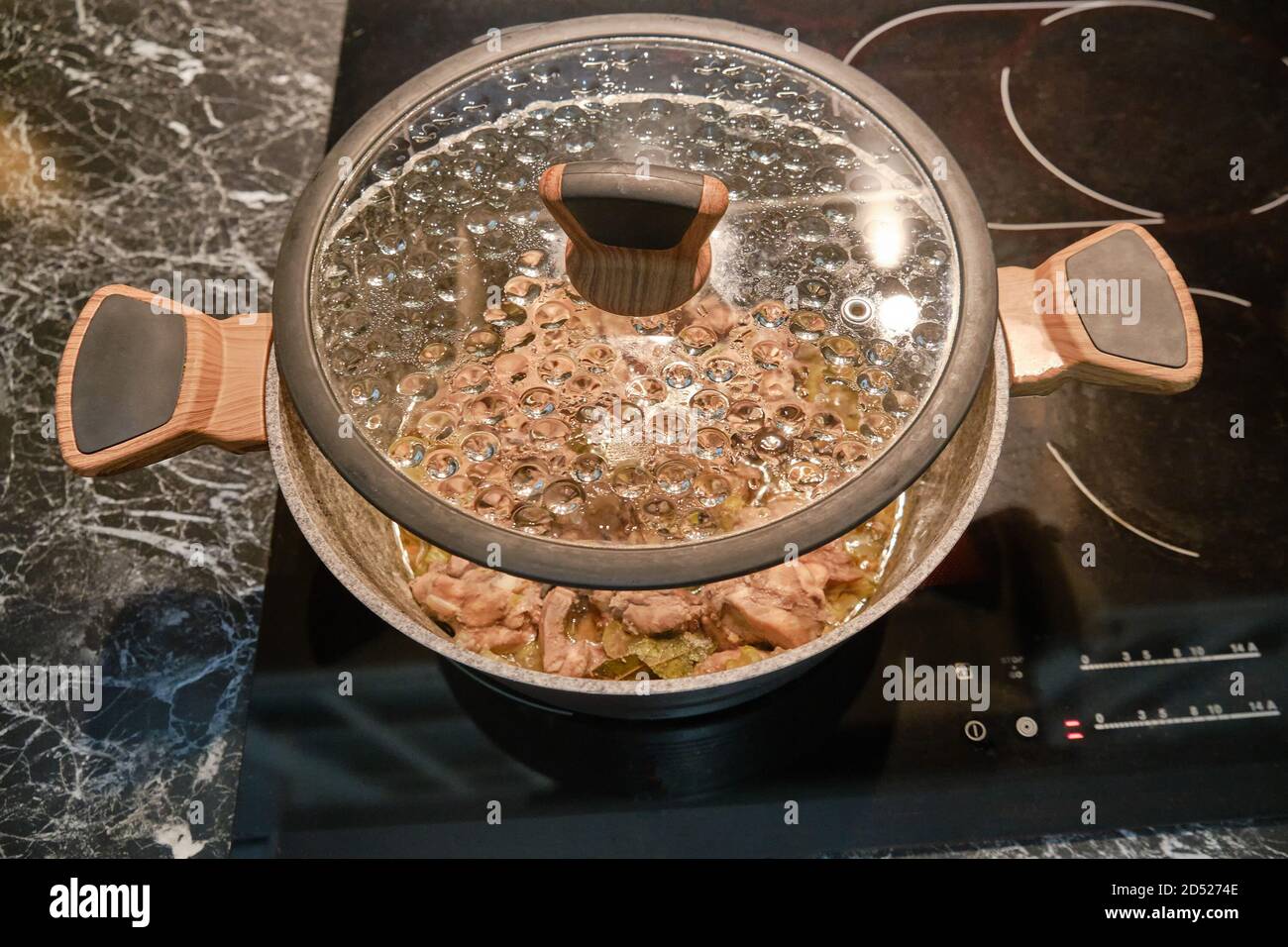 Le pot est placé sur une cuisinière électrique de cuisine avec le couvercle s'ouvre Banque D'Images