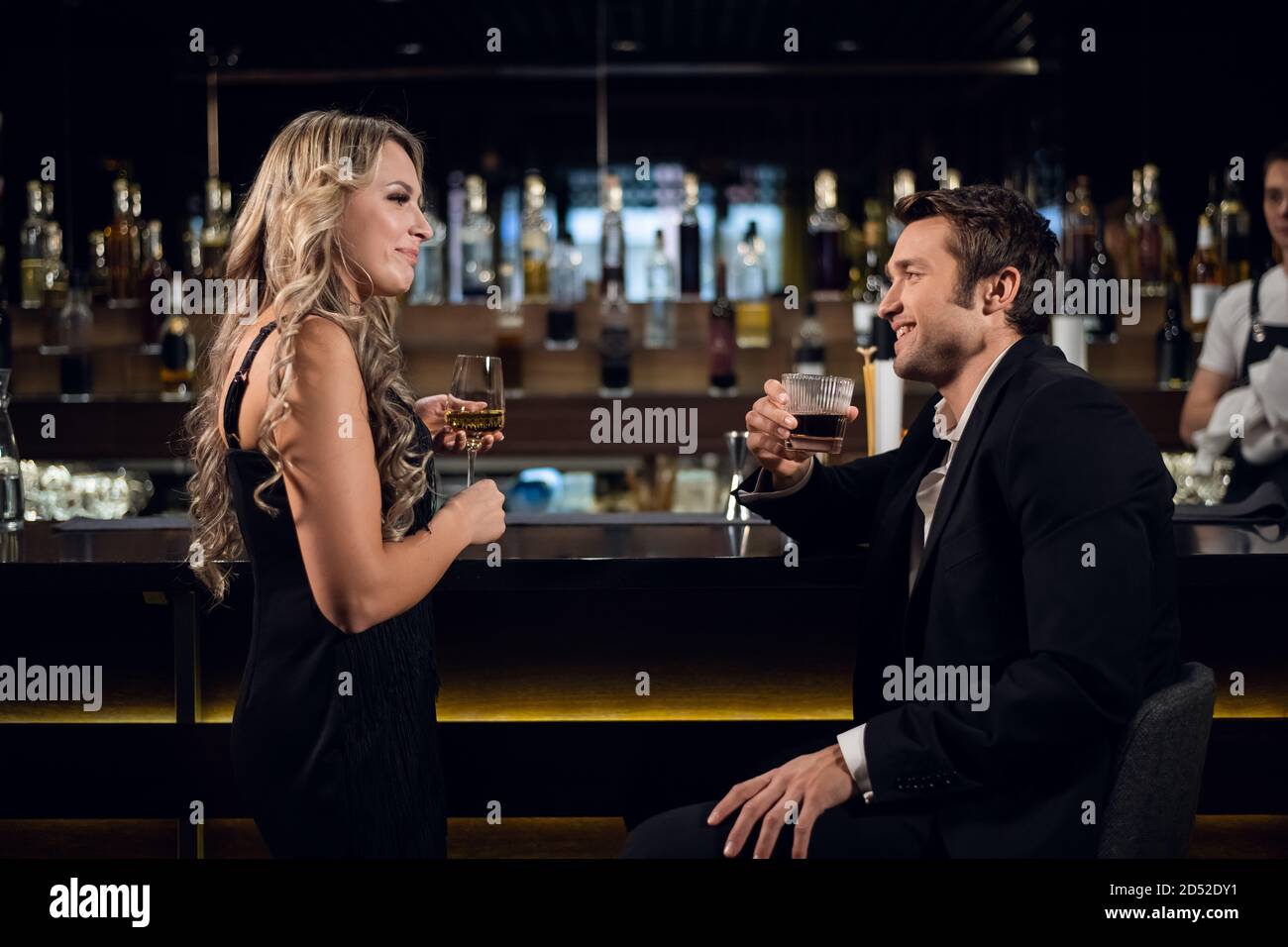 une jeune femme blonde et un homme réussi parlent au bar d'un restaurant  pour boire des cocktails Photo Stock - Alamy