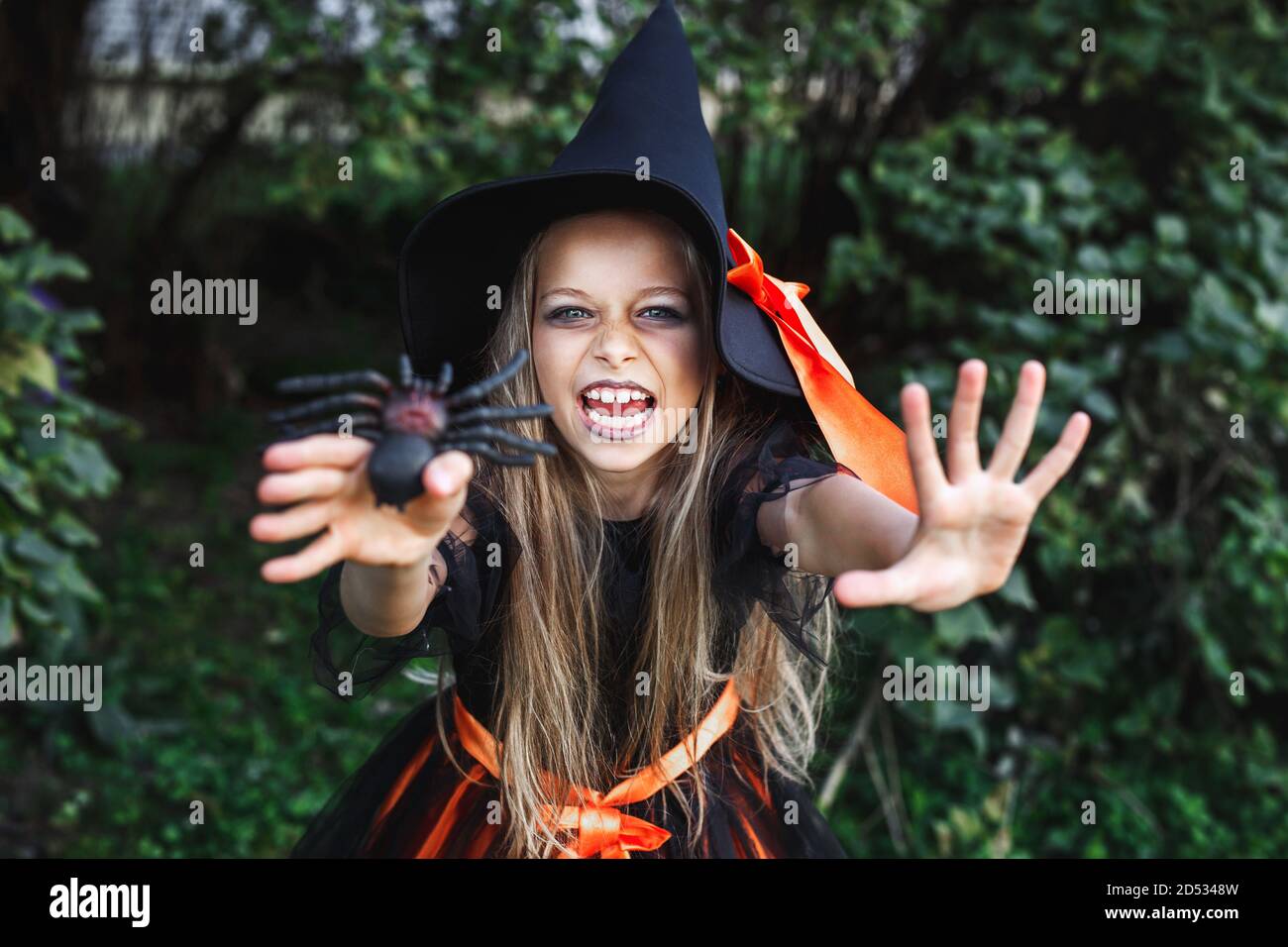 Petite fille en costume de sorcière ayant le plaisir sur Halloween Trick ou traiter Banque D'Images