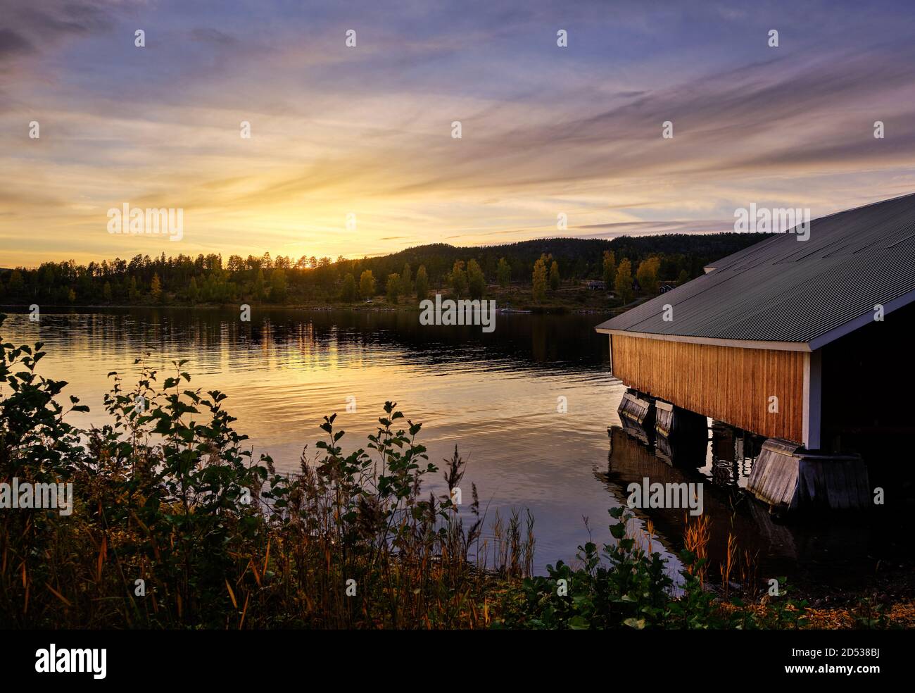 une tour de bateau rouge au bord de la mer avec coucher de soleil dans le arrière-plan Banque D'Images